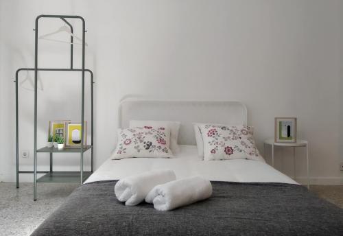 a bedroom with a white bed with two pillows at APT Slow City Hostel in Pontevedra