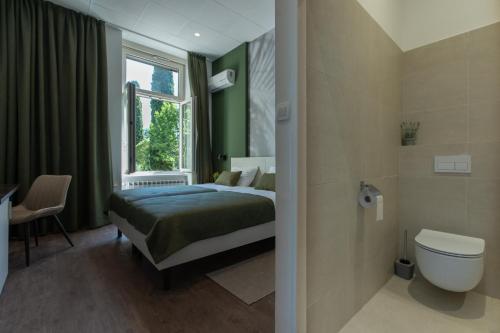 a bedroom with a bed and a toilet and a window at Villa Aurum Health & Climatotherapy Center in Rovinj