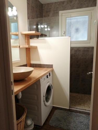 une salle de bain avec une machine à laver et un lavabo dans l'établissement Arrantzaleak, à Hendaye