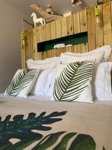 a bed with white pillows and a wooden headboard at B&B La Terre Brûlée in Aigues-Mortes