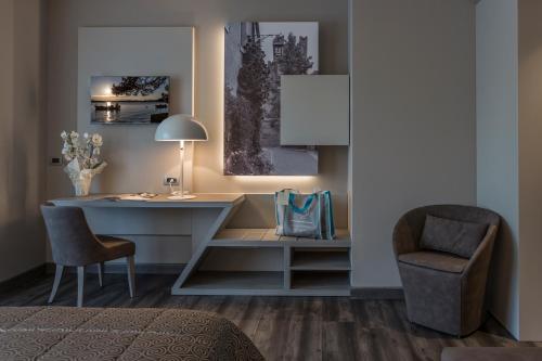 a bedroom with a desk and a chair and a lamp at Hotel Giulietta Romeo in Lazise
