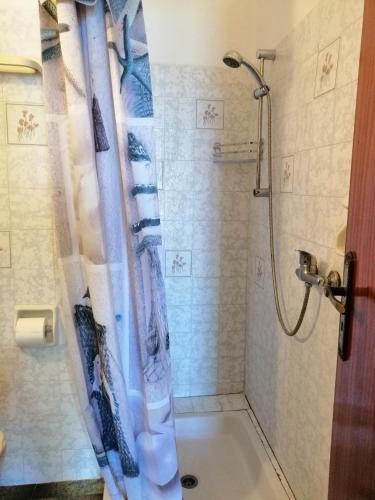 a shower with a shower curtain in a bathroom at Jason Rooms & Studios in Keratokampos