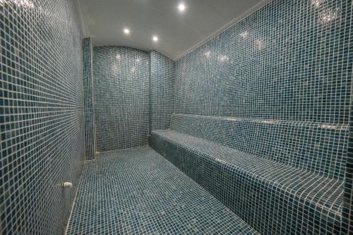 un bagno con doccia con piastrelle blu di Premier Nergis Beach & SPA a Marmaris
