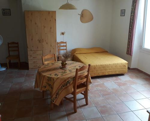 een kamer met een tafel en een bed en een tafel en stoelen bij Studio Appart Verdon in Allemagne-en-Provence