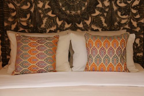 a bed with two pillows and a wall at DECAN Concept Boutique Estate in Rhodes Town