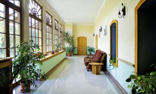a hallway with plants and chairs in a building at Kastiel Lucivna in Lučivná