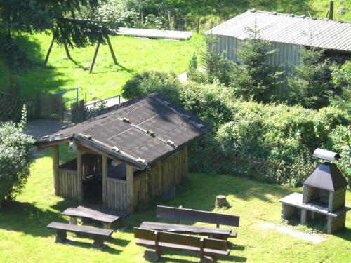 a small wooden cabin with benches and a bird feeder at Zum Kaiserwirt in Heppenheim an der Bergstrasse