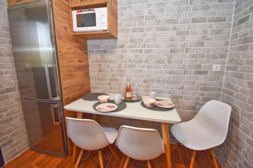 a small kitchen with a table with chairs and a refrigerator at Studio Green in Ýpsos