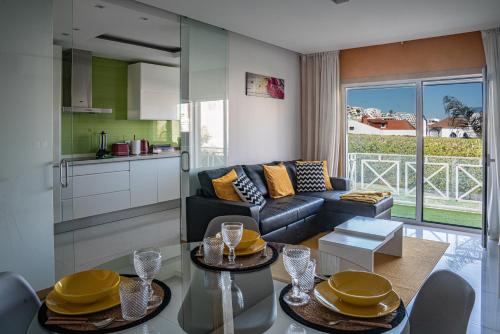 uma sala de estar com um sofá e uma cozinha em Garden Hill Apartment em Albufeira