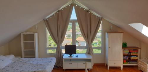 a bedroom with a bed and a tv on a table at El Rincón de las Marismas in Carasa
