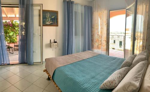 um quarto com uma cama e uma varanda em Seaview Orosei Townhouse by SardiniaGem em Orosei