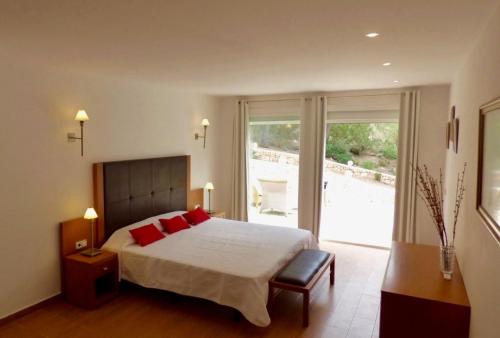 a bedroom with a large bed with red pillows at Can Paredes Ibiza in Ibiza Town