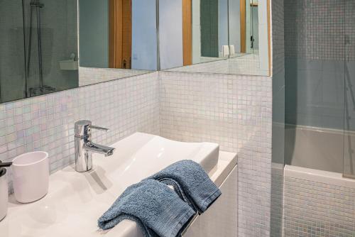 ein weißes Badezimmer mit einem Waschbecken und einem Spiegel in der Unterkunft Garden Hill Apartment in Albufeira