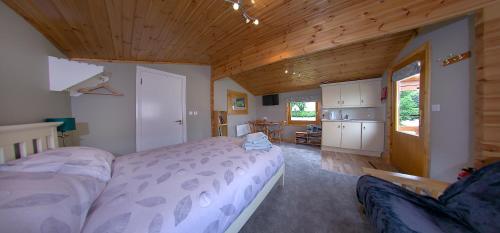 a bedroom with a bed and a wooden ceiling at The Cabin @ Willowmere (Garden Log Cabin) in Clane