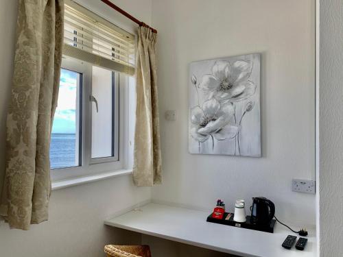 Habitación con ventana y mesa con una foto en Waterfront Inn, en Shanklin