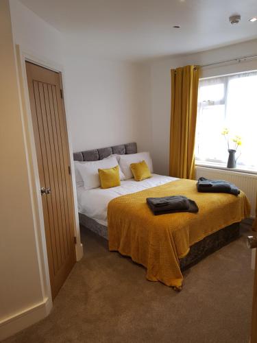 a bedroom with a bed with yellow sheets and a window at Rosie flanagan's in Skegness