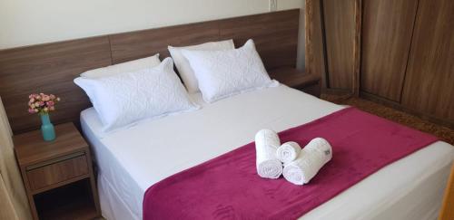 a bedroom with a bed with two slippers on it at Village Duplex Confortável e Acolhedor junto a Natureza in Itacimirim