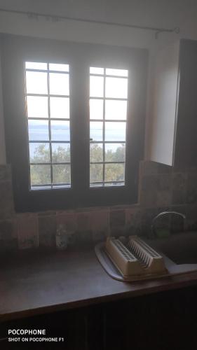 a kitchen counter with two windows in a room at villa Belian 3 in Argalasti