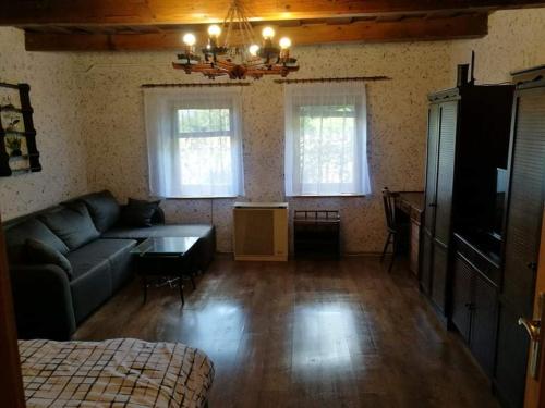 a living room with a couch and two windows at Panoráma Vendégház in Golop