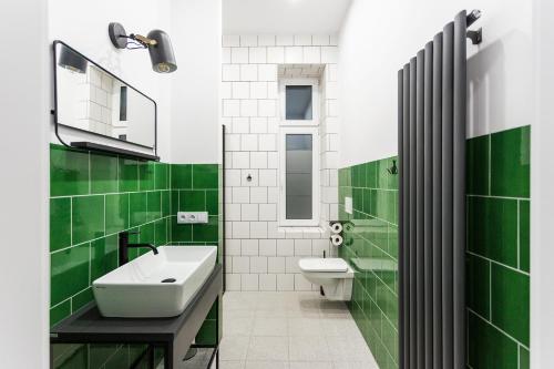 baño verde y blanco con lavabo y aseo en Apartamenty Teatralna, en Katowice