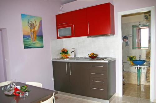 a kitchen with a sink and red cabinets at PIERIDES SUITES in Kardamyli