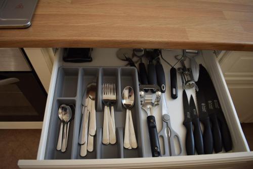 a drawer filled with utensils under a table at Cedar House, formerly Shamrock House in Llandudno