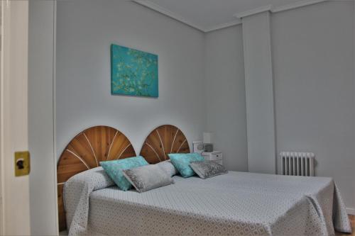 a bedroom with two beds with blue pillows at Apartamento pleno Centro junto Ayuntamiento in Logroño
