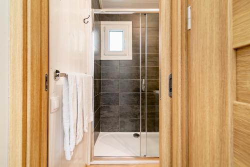 a bathroom with a shower and a bath tub at Les minis homes du Bugey - Eco-lodge City, un refuge en hyper centre in Ambérieu-en-Bugey