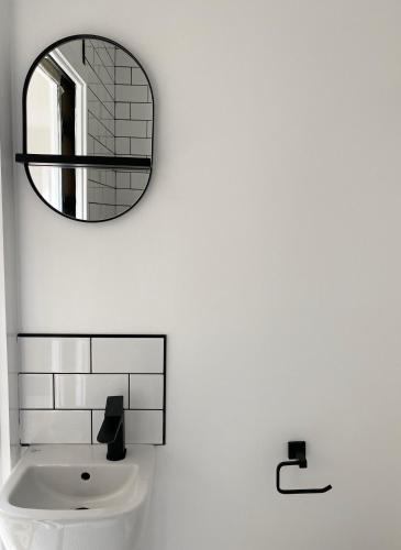 a bathroom with a mirror and a sink at Seaporth Studio St Ives in St Ives