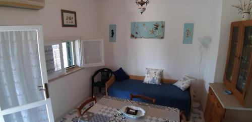 a small room with a blue bed and a table at Villetta dei Limoni in Vulcano