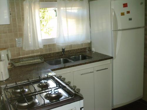 een keuken met een fornuis, een wastafel en een koelkast bij Villa Carlos Paz Alojamiento Santa Ponsa in Villa Carlos Paz