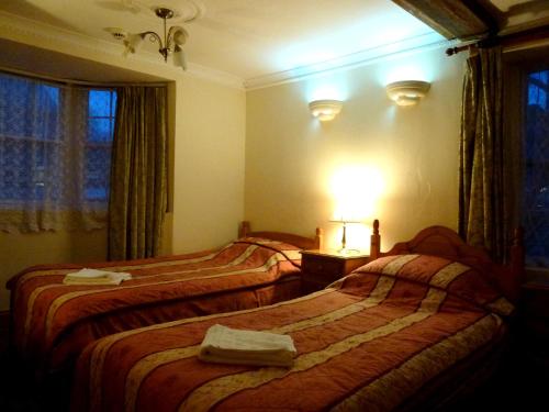 A bed or beds in a room at Riverside Hotel 