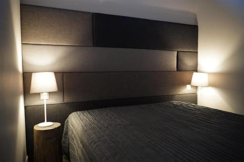 1 dormitorio con 1 cama con cabecero y lámpara en Dizaina apartamenti Saules koks, en Sigulda
