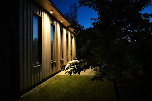 a building at night with a tree in front of it at Dizaina apartamenti Saules koks in Sigulda