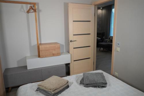 a bedroom with a bed with two towels on it at Dizaina apartamenti Saules koks in Sigulda