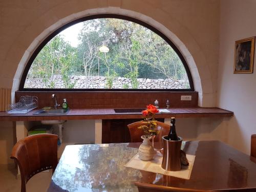 a kitchen with a table and a large window at Trulli Aurasia in Ostuni