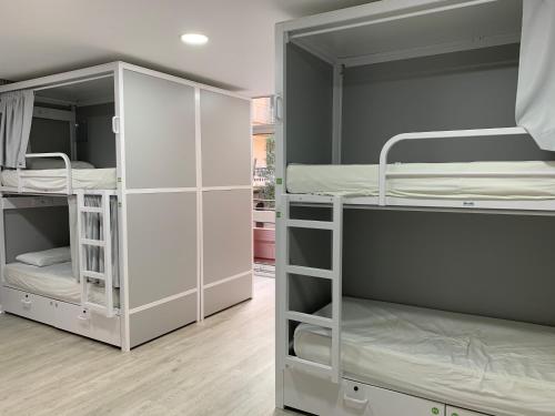 two white bunk beds in a room at Alberguinn in Barcelona