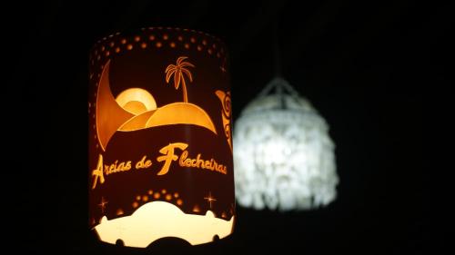 a chandelier and a candle in the dark at Pousada Areias de Flecheiras in Flecheiras