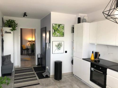 a kitchen with white cabinets and a black counter top at Apartamenty Garden in Słupsk