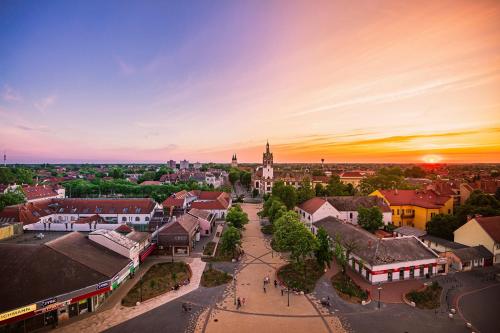 una vista panoramica su una città al tramonto di Belvárosi Apartmanszálló - Kiskunfélegyháza a Kiskunfélegyháza