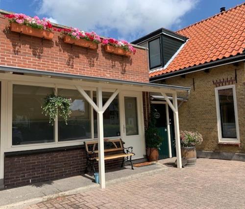 a porch of a house with a bench on it at Oostvoornsch Gastenverblijf in Oostvoorne