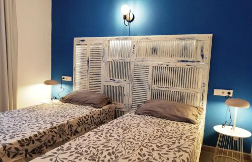 2 letti in una camera con pareti blu di Calamilloraptm2 a Cala Millor