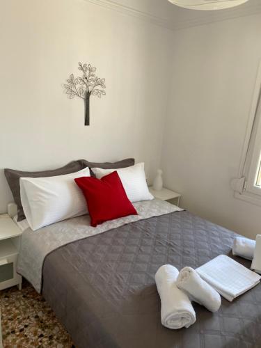 1 dormitorio con 1 cama con almohadas rojas y blancas en Porto, en Ermoupoli