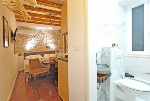 a bathroom with a sink and a toilet and a table at Pearl Stone Apartments in Šibenik