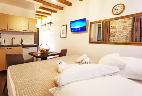 two beds in a room with a kitchen at Pearl Stone Apartments in Šibenik