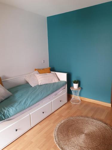 a bedroom with a bed with a blue wall at Studio dans résidence de tourisme*** in Giez
