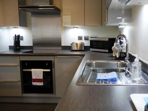 a kitchen with a sink and a counter top at Vikings Two Bedroom Apartment With Free Parking. in York