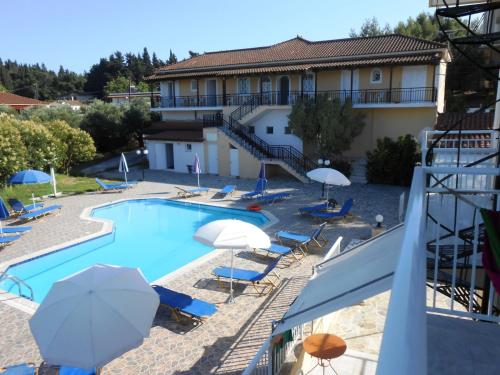a hotel with a swimming pool with chairs and umbrellas at Panagiotis I & II Stds and Apts in Tsilivi