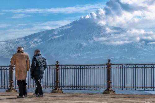 two people standing on a fence looking at a mountain at B&B al centro storico in Troina