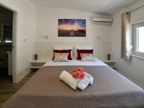een slaapkamer met een groot bed en handdoeken bij Apartmani Antonia in Trogir